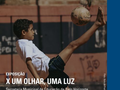 Um menino joga futebol em um campo de terra. Ele está chutando a bola com o pé levantado, usando camiseta branca e shorts escuros. Ao fundo, há um muro com tijolos e pichações. Na parte de cima, está escrito: “04 a 30 de novembro de 2025 – Exposição X Um Olhar, Uma Luz – Secretaria Municipal de Educação de Belo Horizonte.” Abaixo, diz: “MM Gerdau – Museu das Minas e do Metal, Praça da Liberdade, número 680, Prédio Rosa, Belo Horizonte/MG.”