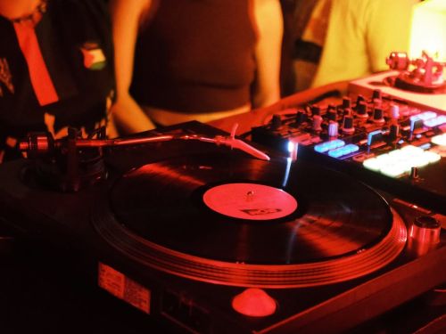 Fotografia da pista de dança e da cdj com vinil tocando.