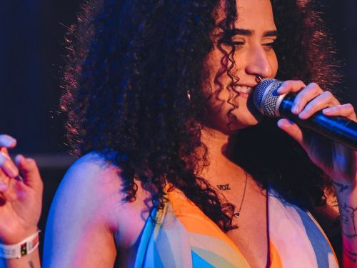 uma mulher cantando com vestido colorido 
