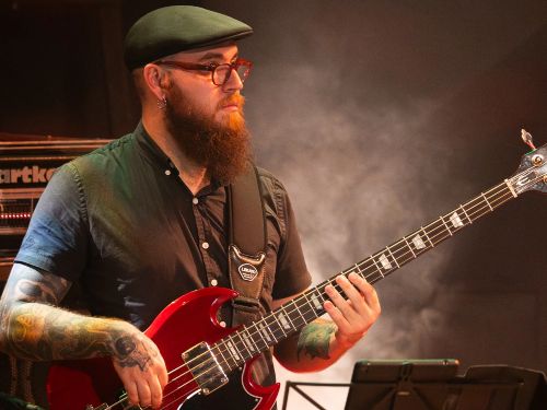 um homem com um instrumento, baixo.