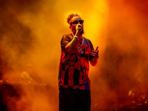 Foto do artista fbc no palco, no fundo laranja