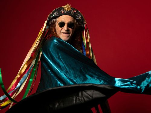 Cantor em performance com roupas coloridas 