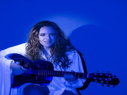 Imagem real de Ana segurando um violão posando para foto 