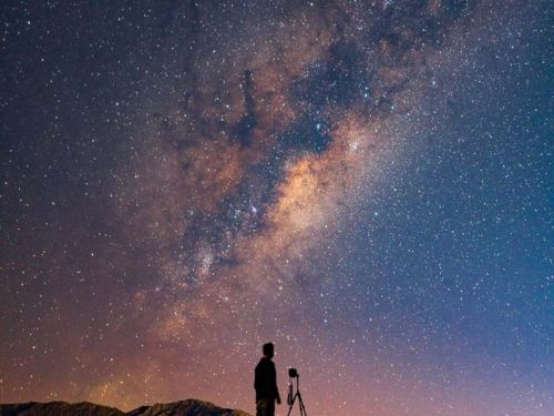 um hjomem olhando para o céu estrelado 