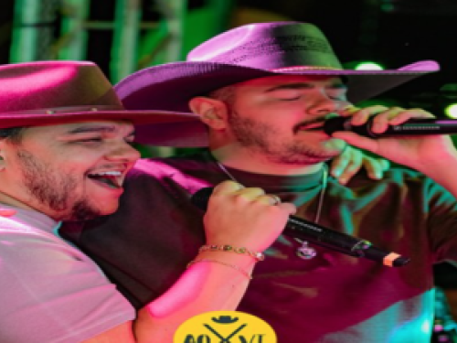 Imagem de dois homens cantando vestidos de agroboy