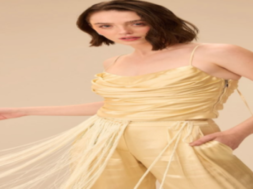 Uma mulher posando para foto vestida de amarelo 