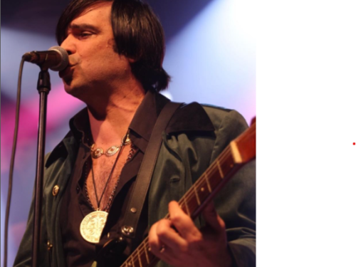 Imagem de um homem cantando com uma guitarra na mão