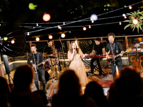 foto de uma artista com banda se apresentando