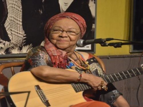 Imagem real de dona Jandira segurando um violão 