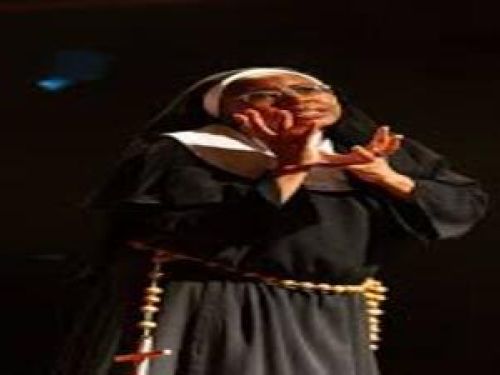 Imagem de uma mulher real vestida de freira fazendo gestos com a mão 