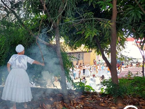 Mulher em trajes umbandistas realizando a defumação