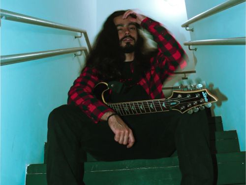 um homem na escada com uma guitarra na mão