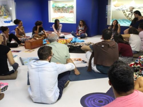 roda de pessoas juntas em ciruclo sentadas no chão 