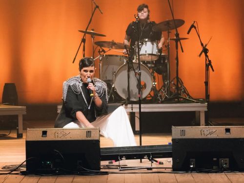 Fotografia da artista Amandona no palco se apresentando 