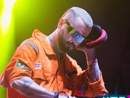 Fotografia do artista DJ Cabra Guaraná ao palco com CDJ