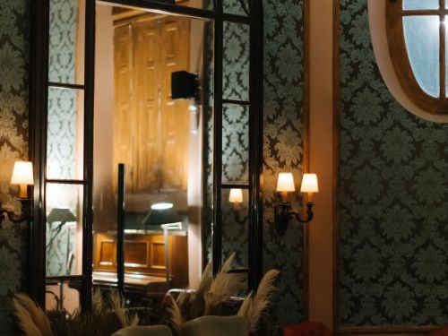 Fotografia do interior do estabelecimento, como luz baixa, parede estampada e cadeiras