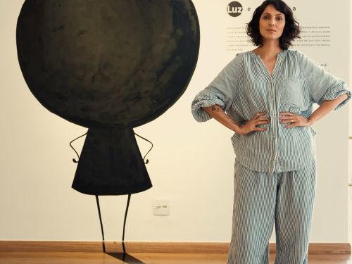 Imagem de uma mulher em pé com as mãos na cintura, e atras a sombra de uma criança desenhada 