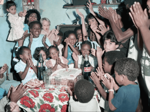 Imagem de varias crianças e adultos em uma festa de aniversario 