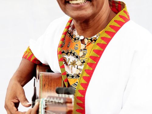 Imagem do artista Pereira da Viola, acompanhado de um violão no fundo branco