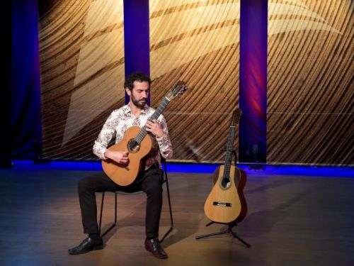 Foto do Gustavo Ramos no palco com dois violões.