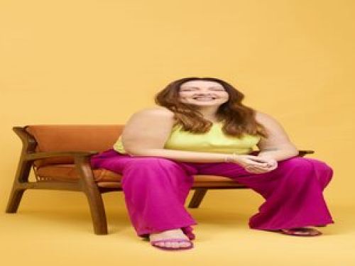 Imagem da comdiante Arianna sentada no sofa 