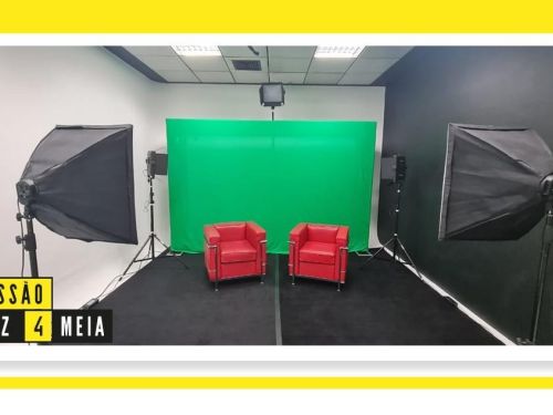 Imagem de um estúdio com fundo verde, duas poltronas vermelhas ao centro e refletores laterais. No canto inferior esquerdo, aparece o texto “Sessão Dez 4 Meia” em destaque.