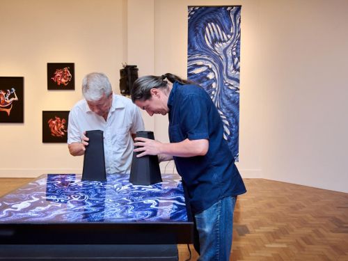 foto de pessoas obeservando as artes da exposição 