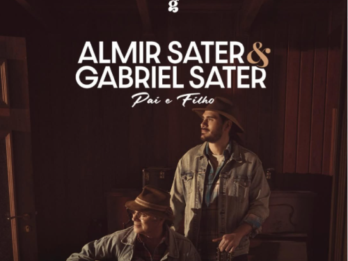 Cartaz musical em tons de sépia com o título "ALMIR SATER & GABRIEL SATER - Pai e Filho". A imagem mostra os dois músicos em um ambiente rústico de madeira que remete a um estúdio ou sala de música. Almir Sater, sentado em primeiro plano à esquerda, segura um violão, enquanto Gabriel Sater está em pé logo atrás dele, à direita, segurando o braço de uma viola. Ambos usam chapéus de aba larga e jaquetas de brim, olhando serenamente para o lado. No topo, há um pequeno logotipo com a letra "g".
