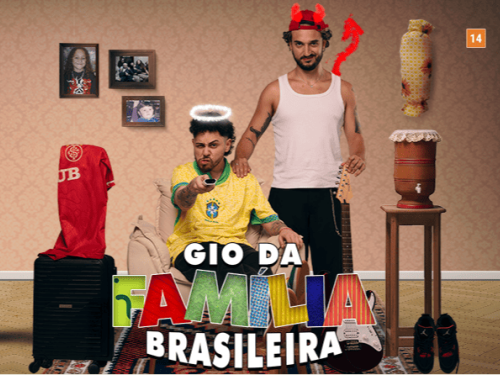 Cartaz do espetáculo "Gio da Família Brasileira" (classificação 14 anos). Em um cenário doméstico, dois homens estão ao centro: um sentado com a camisa da seleção e auréola de anjo, e outro em pé atrás dele com chifres e rabo de diabo. O ambiente é decorado com ícones do cotidiano brasileiro, como filtro de barro, quadros de família, violão e uma mala com camisa de time.