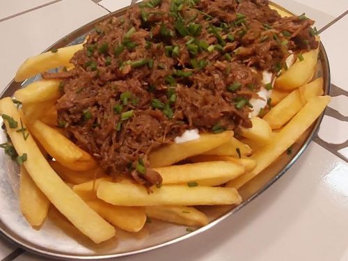 Porção de batata frita com carne e queijo.