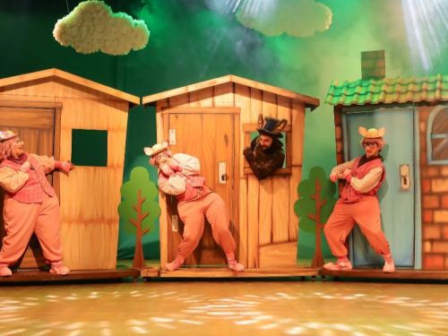 Foto de uma das cenas do espetáculo com os três porquinhos 
