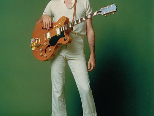 Fotografia do artista Tim Bernardes com fundo verde