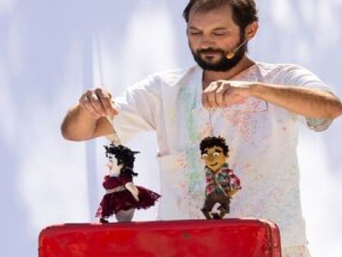 Imagem de um homem brincando com bonecos 