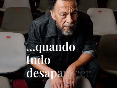 Foto de um dos artistas do espetaculo atrás do titulo da obra "quando tudo desaparecer"