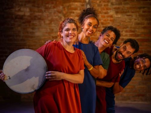 tres mulheres de pé e sorrindo