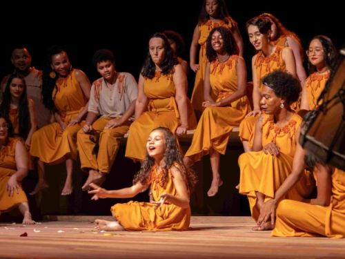 mulheres vestidos de amarelo e vendendo uma menina cantando 