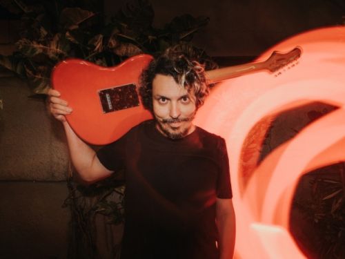 foto do cantor com uma guitarra 