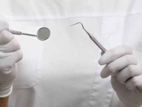 Foto de uma dentista segurando instrumentos dentários 