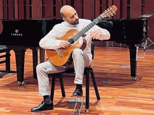 Foto do artista tocando violão 