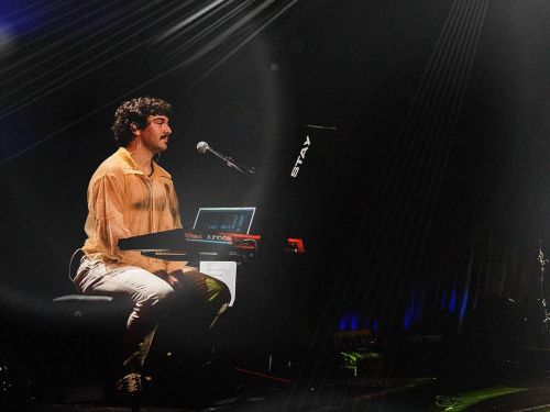 Foto do cantor Dudu Amendoeira no palco 