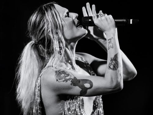 Foto da cantora Catto em preto e branco cantando 