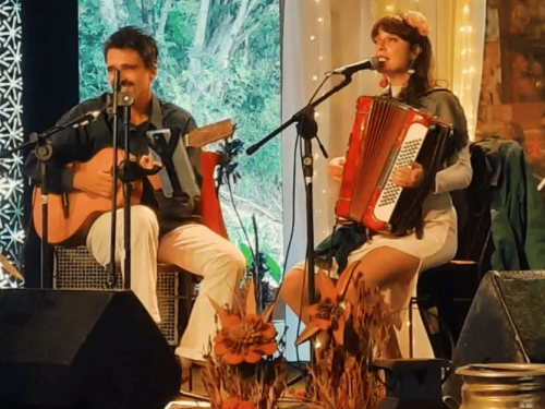 Foto dos artistas Calebe Violeiro e Nanda Dearo tocando juntos