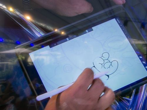 Imagem de um quadrinista desenhando em um tablet