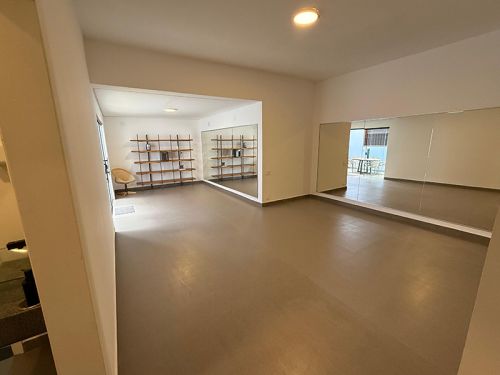 Foto da parte interna do Espaçoi Cultural Poleiro: espaço amplo com parade espelhada 