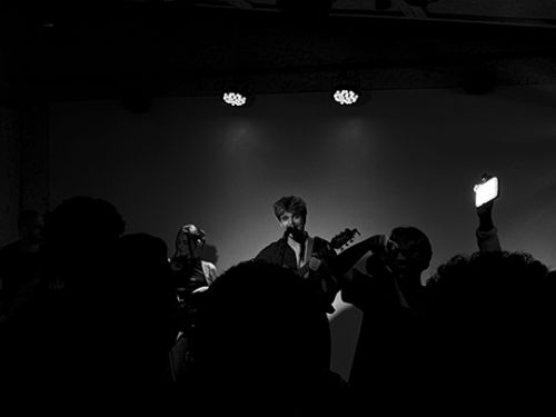 Foto preto e branco de um dos professores do espaço tocando no palco 