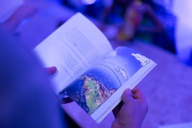 a imagem mostra uma pessoa folheando um livro. 