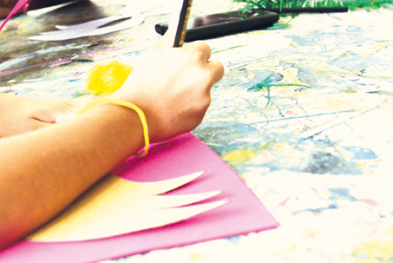 Pessoa segurando um lápis e colorindo 