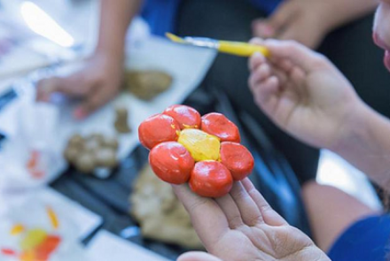 menina pintando uma flor 