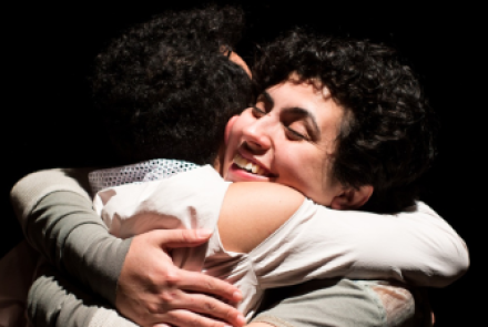 Foto em close de duas pessoas se abraçando