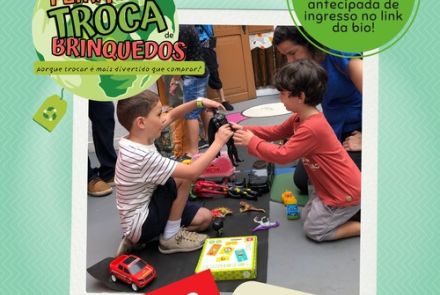 Duas crianças brincando com brinquedos na mão e uma mãe acompanhando 